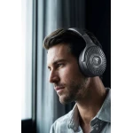 Man wearing over-ear Focal headphones, gazing out a window in a contemplative pose.