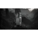 High-end floor-standing speaker with multiple drivers set on a rocky, monochrome landscape.