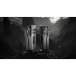 Pair of tall, modern floor-standing speakers with multiple drivers, set on stands in a dark, rocky mountain landscape (monochrome).