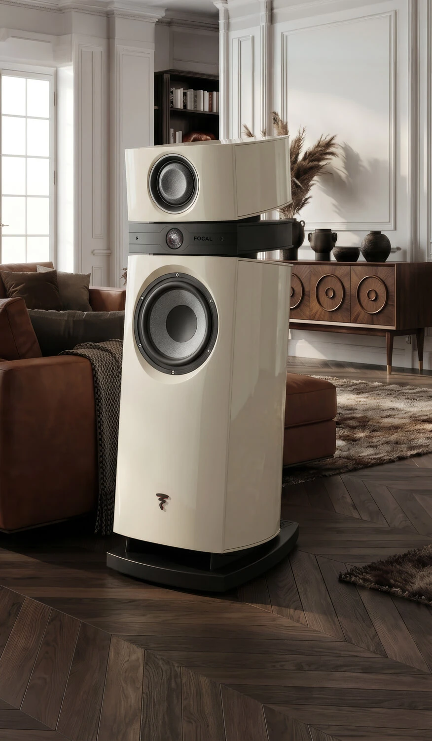 Luxury white floor-standing speaker system with a subwoofer in a refined living room setting.