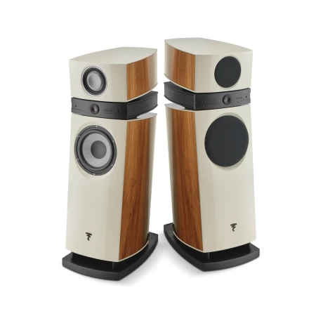 Pair of cream-colored floor-standing speakers with wood veneer panels and black drivers, facing each other in a studio setup.