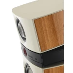 Close-up of a cream-colored speaker cabinet with a wood veneer panel and a visible driver (Focal brand).